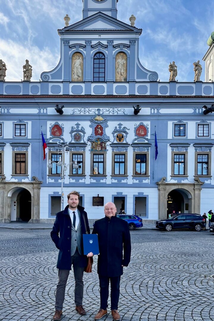 Starosta a radní pro kulturu z Broumova stojí před radnicí v ČB